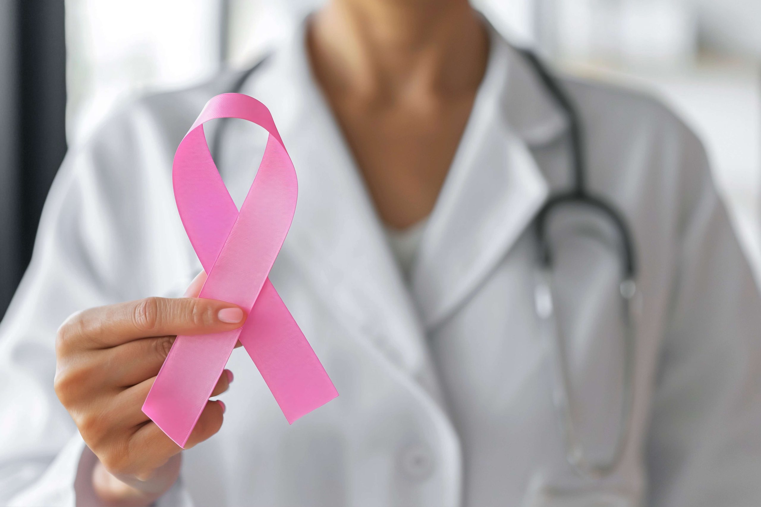 Doctor holding a pink breast cancer awareness ribbon